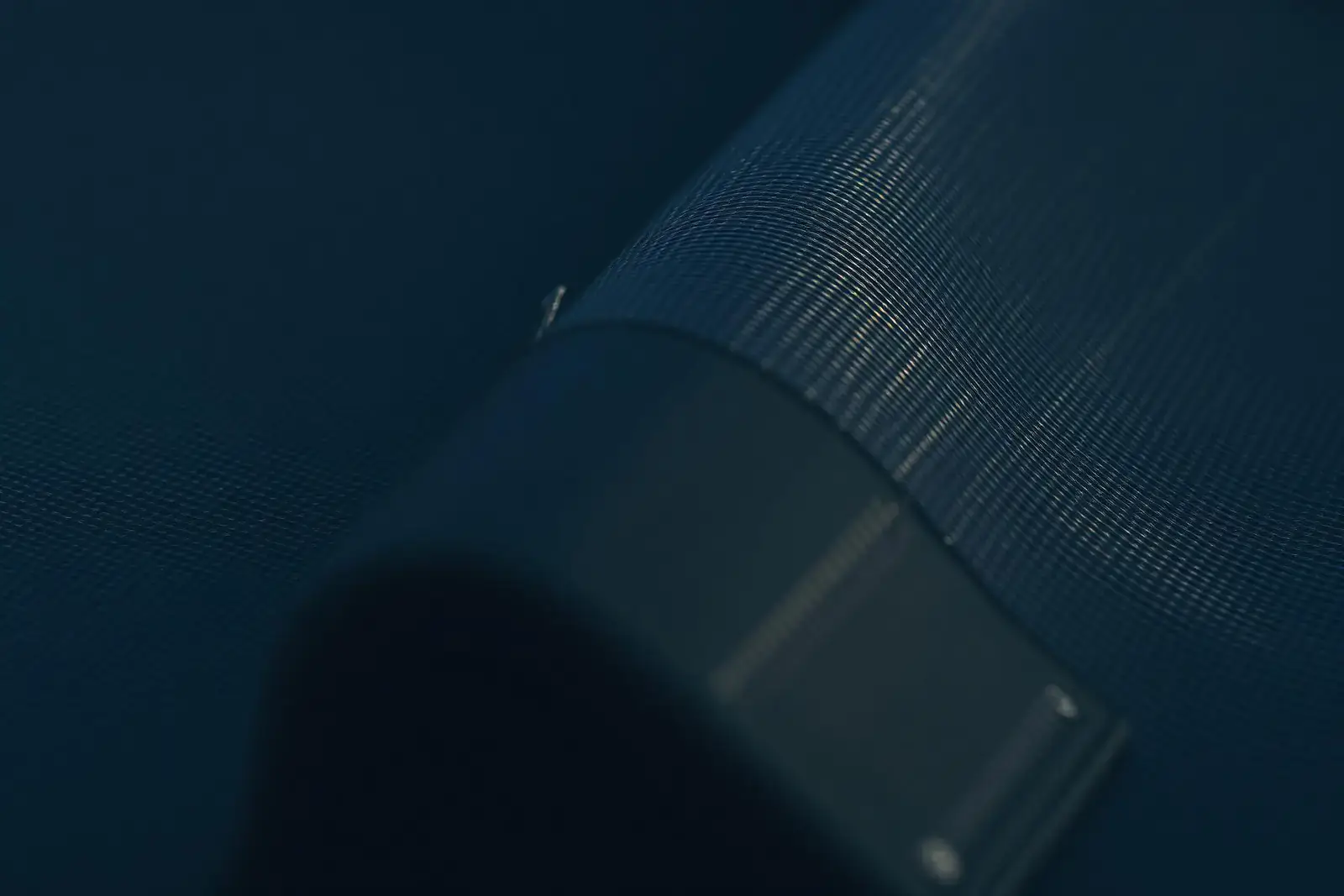 Macro close-up of woven scrim inside a reinforced polymer pond liner